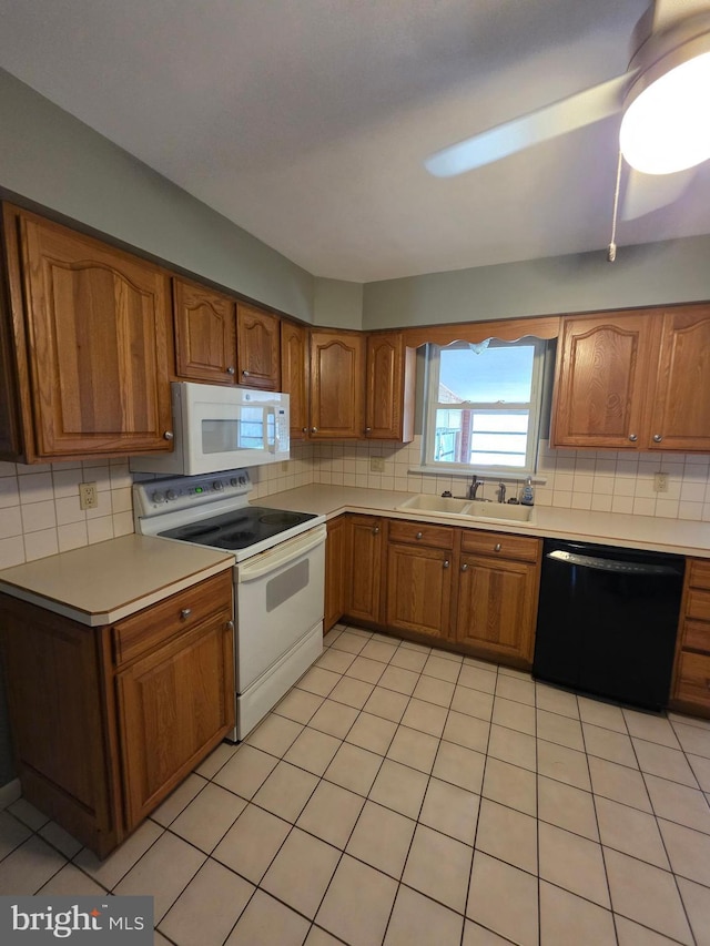 616 Sylvan Pl, Harrisburg, PA 17109 - kitchen featuring white appliances, brown cabinetry, decorative backsplash, and a sink