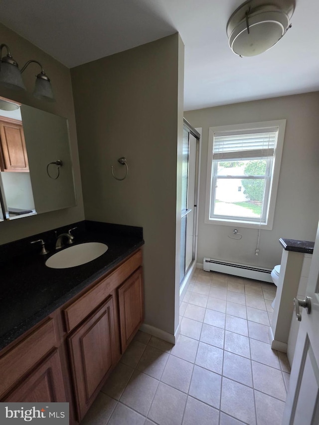 616 Sylvan Pl, Harrisburg, PA 17109 - bathroom featuring a baseboard heating unit, toilet, a shower stall, tile patterned flooring, and baseboards