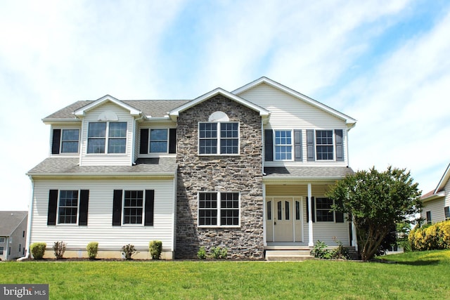 traditional-style house with a front lawn and stone siding