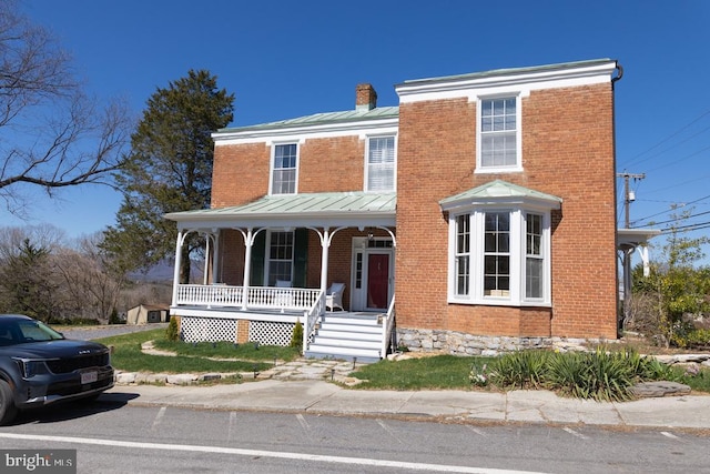 322 Main St E, Fincastle, VA 24090 - view of front of house with covered porch, a standing seam roof, brick siding, a chimney, and metal roof