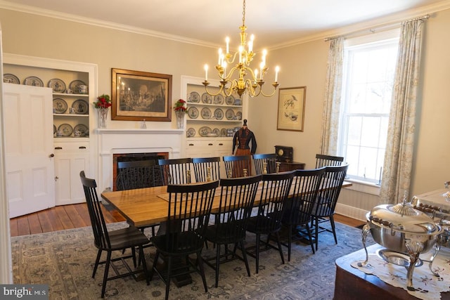 322 Main St E, Fincastle, VA 24090 - dining room with wood finished floors, a chandelier, crown molding, built in features, and a fireplace