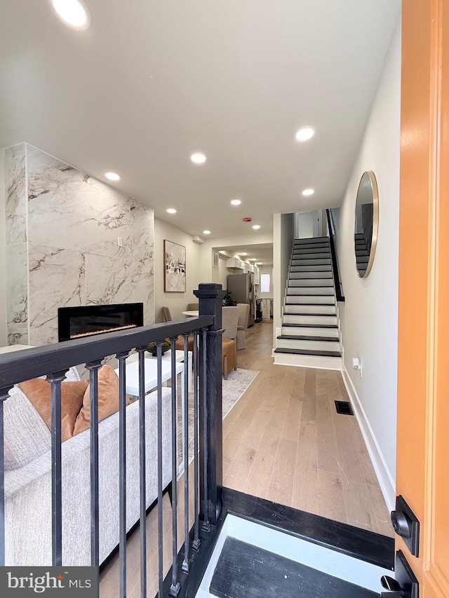 2112 Llewelyn Ave, Baltimore, MD 21213 - stairs featuring a premium fireplace, recessed lighting, baseboards, and wood finished floors
