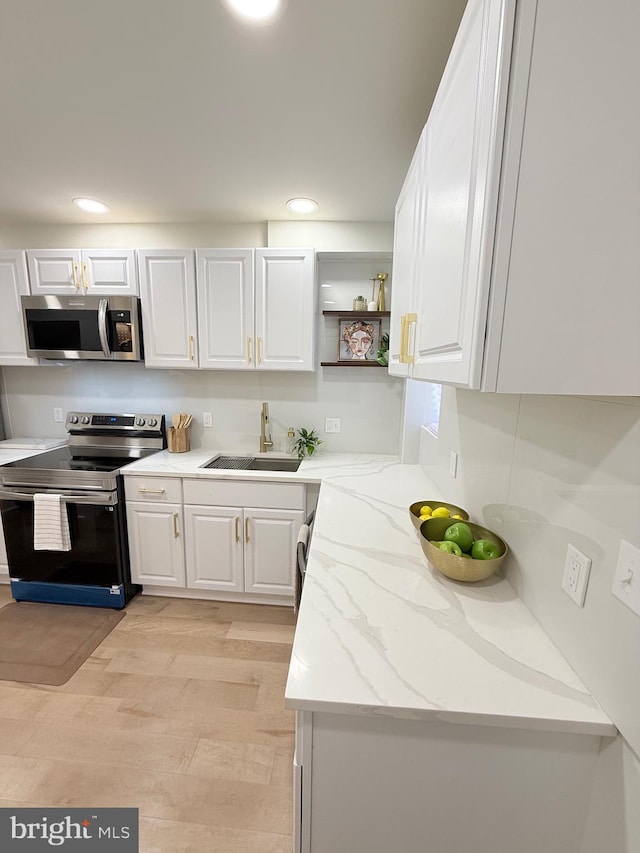 2112 Llewelyn Ave, Baltimore, MD 21213 - kitchen with appliances with stainless steel finishes, a sink, white cabinets, light wood-style flooring, and recessed lighting