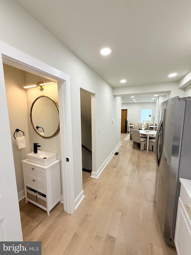 2112 Llewelyn Ave, Baltimore, MD 21213 - corridor featuring a sink, light wood-style flooring, recessed lighting, and baseboards
