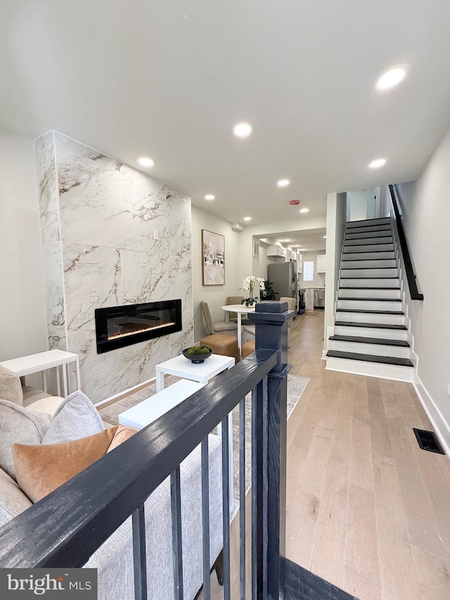 2112 Llewelyn Ave, Baltimore, MD 21213 - living area featuring a premium fireplace, recessed lighting, wood finished floors, stairway, and baseboards