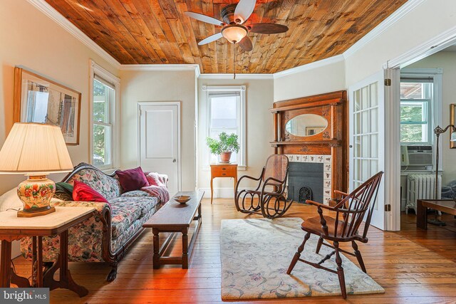 922 8th Ave, Prospect Park, PA 19076 - living room featuring crown molding, radiator heating unit, ceiling fan, a tile fireplace, and wood ceiling