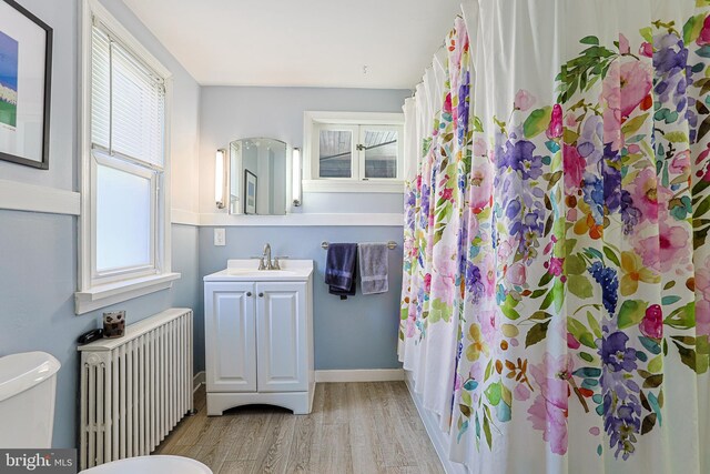 922 8th Ave, Prospect Park, PA 19076 - full bath featuring radiator heating unit, wood finished floors, toilet, vanity, and a shower with shower curtain