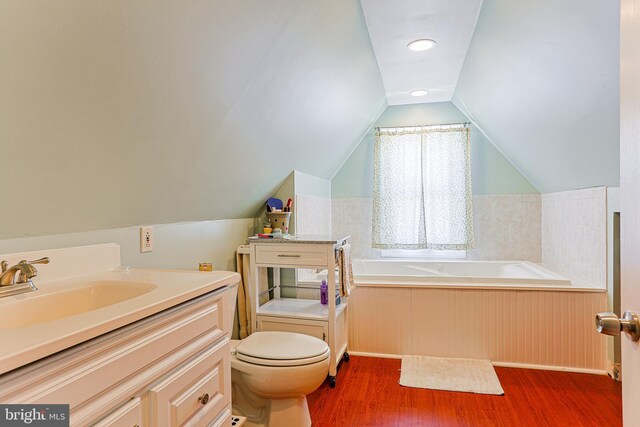 922 8th Ave, Prospect Park, PA 19076 - bathroom featuring wood finished floors, toilet, a garden tub, a sink, and vaulted ceiling