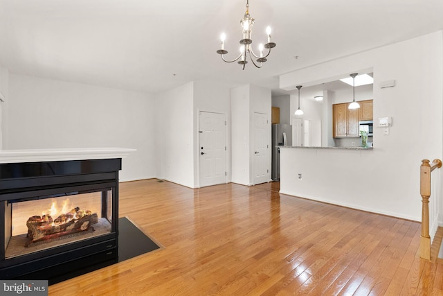13800 Breezy Ridge Way Unit 101, Woodbridge, VA 22191 - unfurnished living room with light wood-style floors, a chandelier, and baseboards