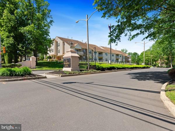 902 Scotswood Ct, Mount Laurel, NJ 08054 - view of asphalt road featuring street lights, curbs, a residential view, and a gate
