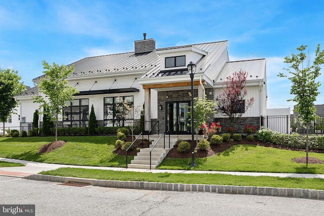 131 Junction Rd, Media, PA 19063 - view of front facade with a standing seam roof, stone siding, a chimney, and metal roof