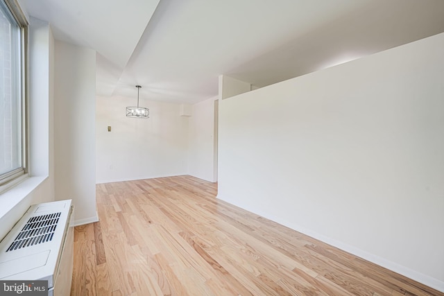 4000 Tunlaw Rd NW Unit 602, Washington, DC 20007 - empty room featuring light wood-style floors, a chandelier, an AC wall unit, and baseboards