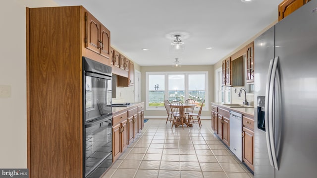1702 Ferry Point Ct, Trappe, MD 21673 - kitchen with stainless steel appliances, a sink, light countertops, baseboards, and brown cabinets