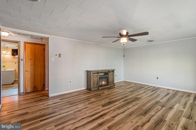 230 N Harrison St, Palmyra, PA 17078 - unfurnished living room featuring wood finished floors, ceiling fan, a glass covered fireplace, baseboards, and crown molding