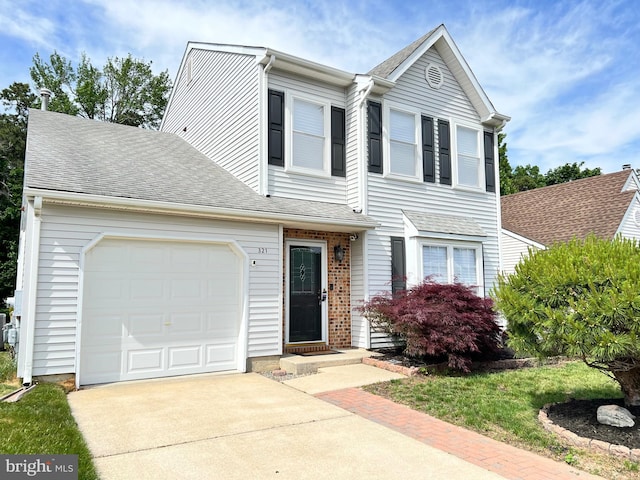 view of front of house with driveway, an attached garage, and a shingled roof