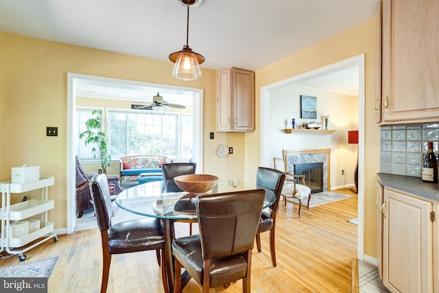 5518 Kempton Dr, Springfield, VA 22151 - dining room featuring light wood-style flooring, a high end fireplace, ceiling fan, and baseboards