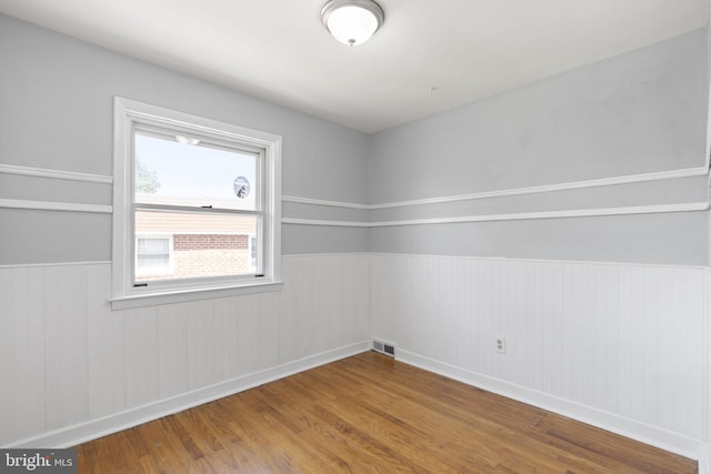 4022 Evans Ln, Drexel Hill, PA 19026 - empty room with wood finished floors, a wainscoted wall, and baseboards