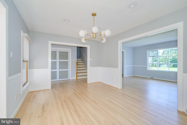 1104 Milroy Ct, Winchester, VA 22601 - empty room with light wood-style floors, a chandelier, and stairs