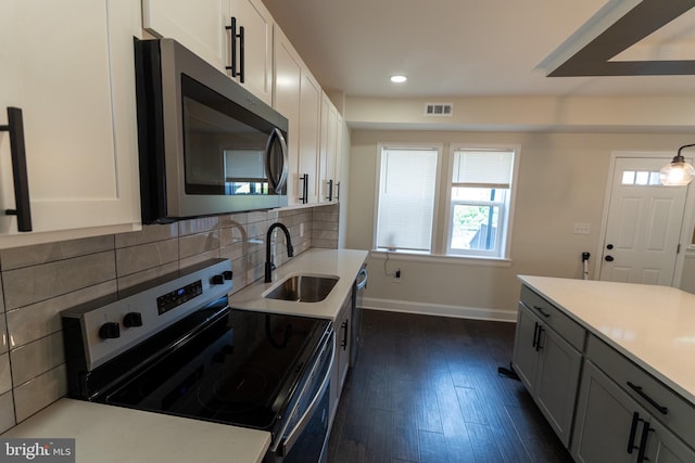 3815 Cottage Ave, Baltimore, MD 21215 - kitchen featuring stainless steel appliances, a sink, baseboards, dark wood-style flooring, and tasteful backsplash