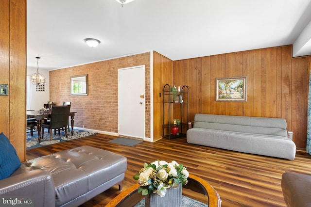 6034 Westchester Park Dr Unit 202, College Park, MD 20740 - living area with a chandelier, brick wall, wood finished floors, baseboards, and wood walls
