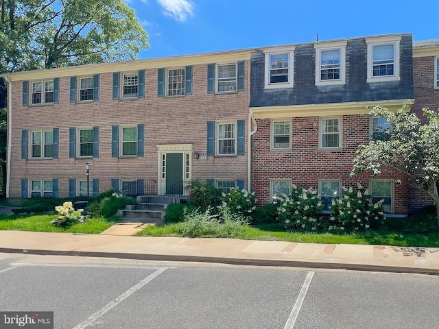 6034 Westchester Park Dr Unit 202, College Park, MD 20740 - view of front of house with uncovered parking, mansard roof, and brick siding