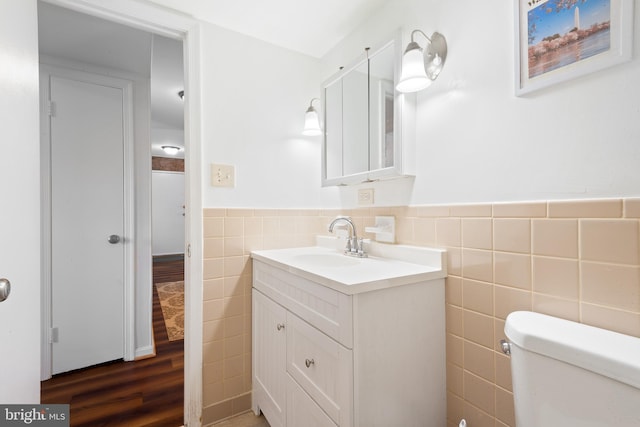 6034 Westchester Park Dr Unit 202, College Park, MD 20740 - bathroom featuring tile walls, vanity, a wainscoted wall, toilet, and wood finished floors