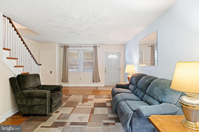 7164 Walker St, Philadelphia, PA 19135 - living room featuring a textured ceiling, light wood-type flooring, stairs, and baseboards