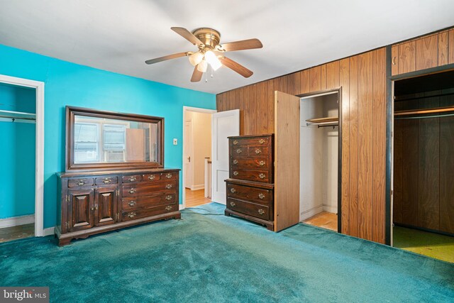 7164 Walker St, Philadelphia, PA 19135 - unfurnished bedroom with multiple closets, carpet flooring, ceiling fan, wooden walls, and baseboards