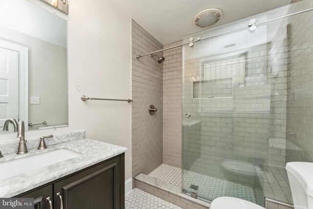 1419 Clifton St NW Unit 101, Washington, DC 20009 - bathroom featuring toilet, vanity, a stall shower, and tile patterned flooring