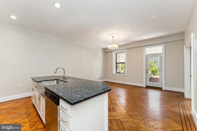 1419 Clifton St NW Unit 101, Washington, DC 20009 - kitchen with stainless steel dishwasher, a sink, white cabinetry, a center island with sink, and baseboards