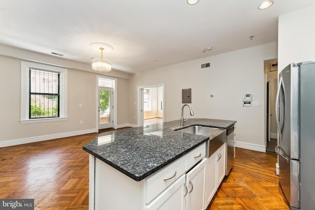 1419 Clifton St NW Unit 101, Washington, DC 20009 - kitchen with stainless steel appliances, a sink, white cabinetry, a center island with sink, and baseboards