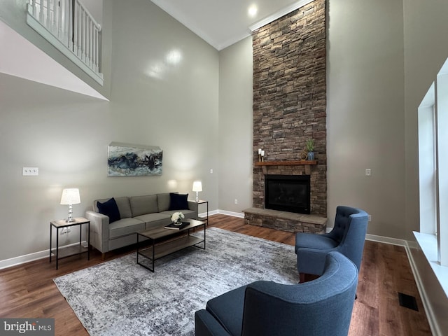 857 Barcelona St, Townsend, DE 19734 - living area featuring a towering ceiling, a fireplace, wood finished floors, baseboards, and crown molding