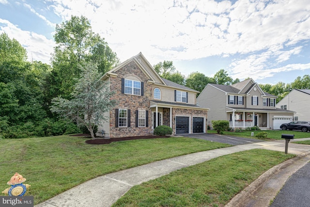 857 Barcelona St, Townsend, DE 19734 - view of front facade featuring stone siding, asphalt driveway, an attached garage, and a front yard
