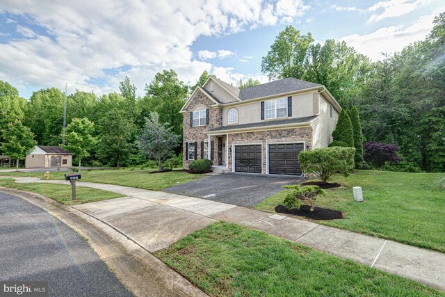 857 Barcelona St, Townsend, DE 19734 - view of front of property featuring asphalt driveway, a garage, a front yard, and stone siding