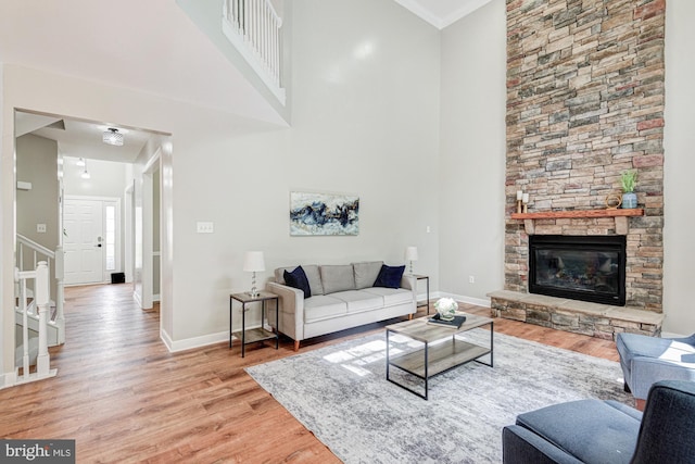 857 Barcelona St, Townsend, DE 19734 - living room with light wood-type flooring, baseboards, stairway, a fireplace, and a high ceiling