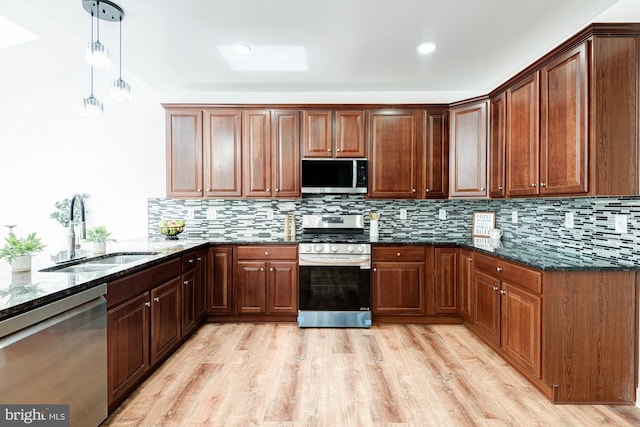 857 Barcelona St, Townsend, DE 19734 - kitchen with stainless steel appliances, a sink, light wood finished floors, dark stone counters, and tasteful backsplash