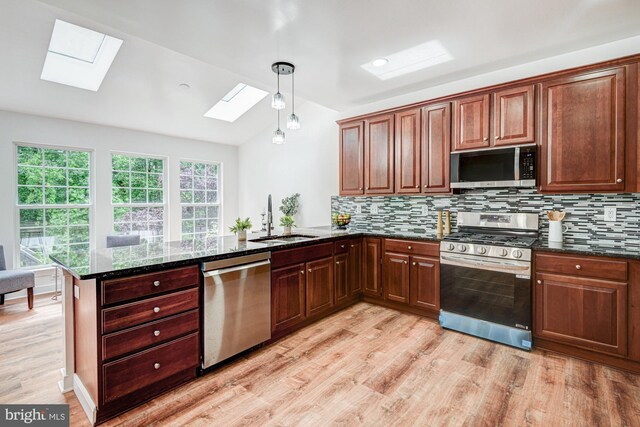 857 Barcelona St, Townsend, DE 19734 - kitchen featuring stainless steel appliances, a skylight, a sink, lofted ceiling, and light wood-style floors