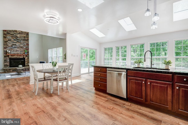 857 Barcelona St, Townsend, DE 19734 - kitchen featuring stainless steel dishwasher, a sink, a skylight, vaulted ceiling, and a stone fireplace