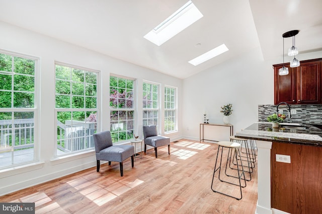 857 Barcelona St, Townsend, DE 19734 - living area featuring a skylight, vaulted ceiling, light wood-style floors, and baseboards