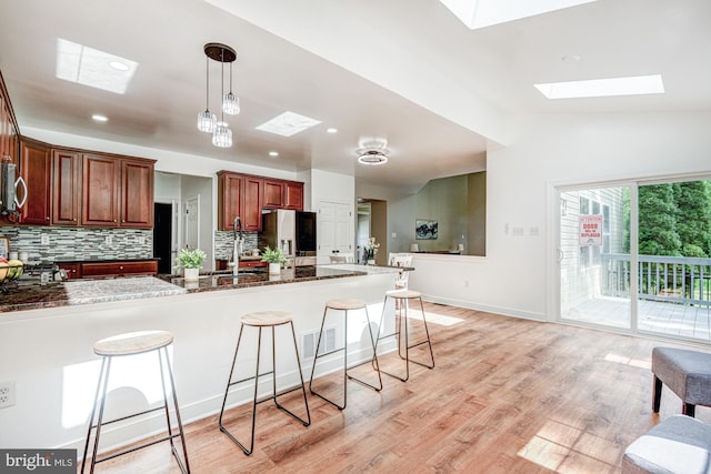 857 Barcelona St, Townsend, DE 19734 - kitchen with appliances with stainless steel finishes, a skylight, a breakfast bar, tasteful backsplash, and vaulted ceiling