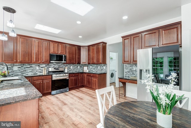 857 Barcelona St, Townsend, DE 19734 - kitchen with stainless steel appliances, a sink, washer / clothes dryer, backsplash, and light wood finished floors