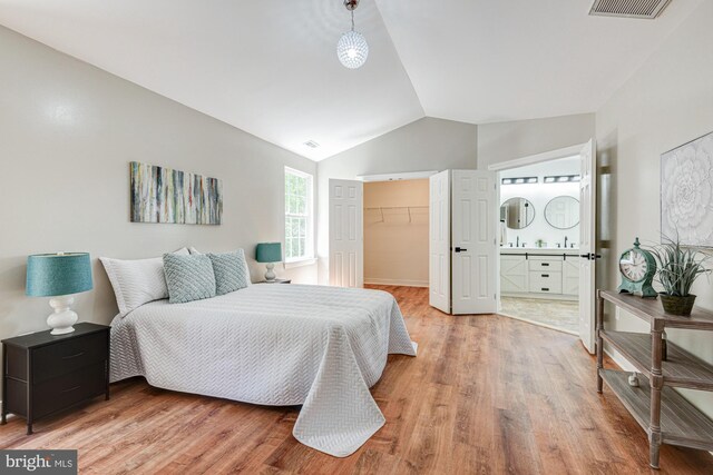 857 Barcelona St, Townsend, DE 19734 - bedroom featuring light wood finished floors, vaulted ceiling, a spacious closet, and ensuite bath