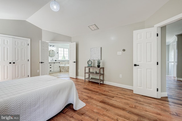 857 Barcelona St, Townsend, DE 19734 - bedroom with lofted ceiling, light wood-style flooring, baseboards, ensuite bath, and a sink