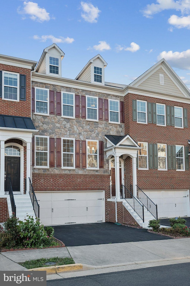 20677 Erskine Ter, Ashburn, VA 20147 - townhome / multi-family property featuring an attached garage, asphalt driveway, and stone siding