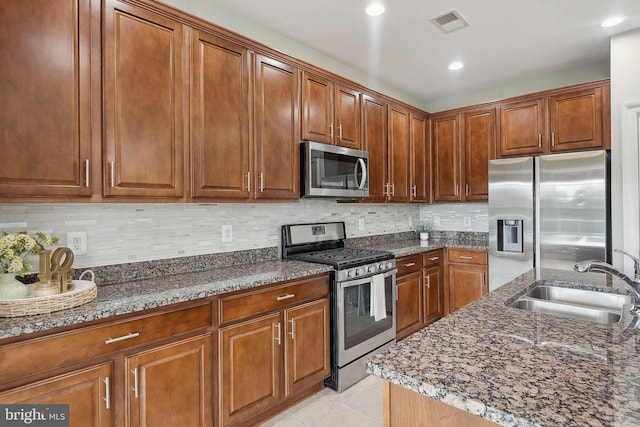 20677 Erskine Ter, Ashburn, VA 20147 - kitchen with stainless steel appliances, a sink, dark stone countertops, light tile patterned floors, and recessed lighting
