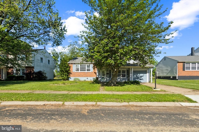 116 Layton Dr, New Castle, DE 19720 - view of property hidden behind natural elements with concrete driveway, a garage, a front lawn, and brick siding