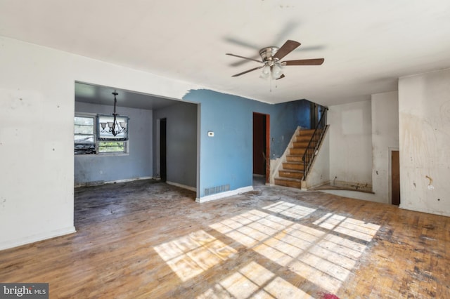 116 Layton Dr, New Castle, DE 19720 - unfurnished living room featuring ceiling fan, wood finished floors, stairway, and a chandelier