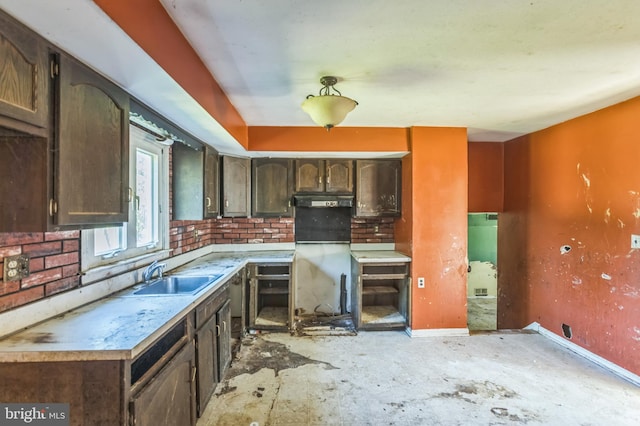 116 Layton Dr, New Castle, DE 19720 - kitchen featuring a sink, dark brown cabinets, baseboards, light countertops, and fridge