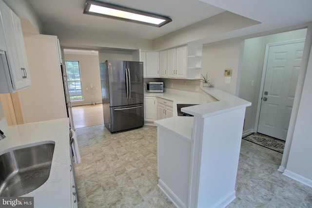 813 Pointer Ridge Dr, Gaithersburg, MD 20878 - kitchen featuring freestanding refrigerator, stainless steel microwave, a sink, a peninsula, and white cabinets