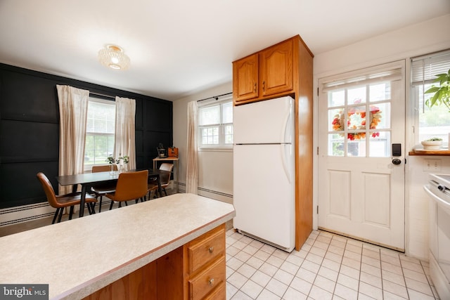 200 Maplewood Dr Unit 20, Pottstown, PA 19464 - kitchen with freestanding refrigerator, brown cabinets, light countertops, light tile patterned flooring, and range